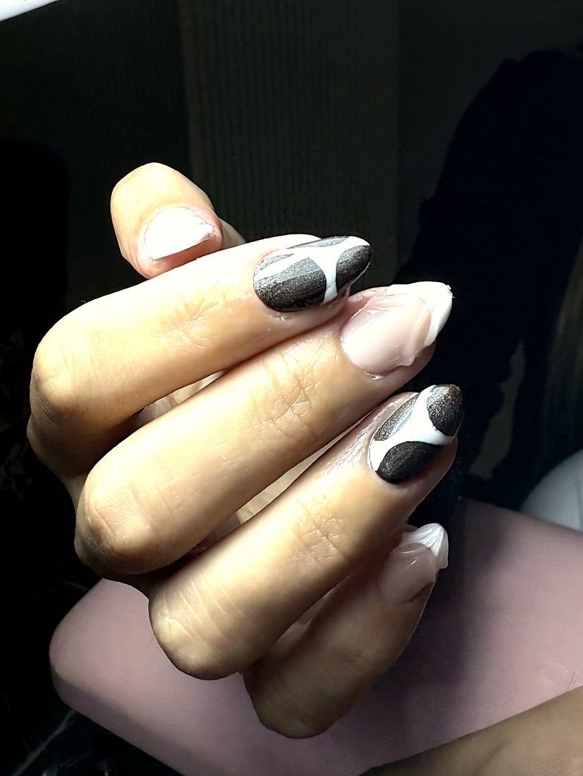 Detalle de uñas almendradas con diseño en negro y blanco